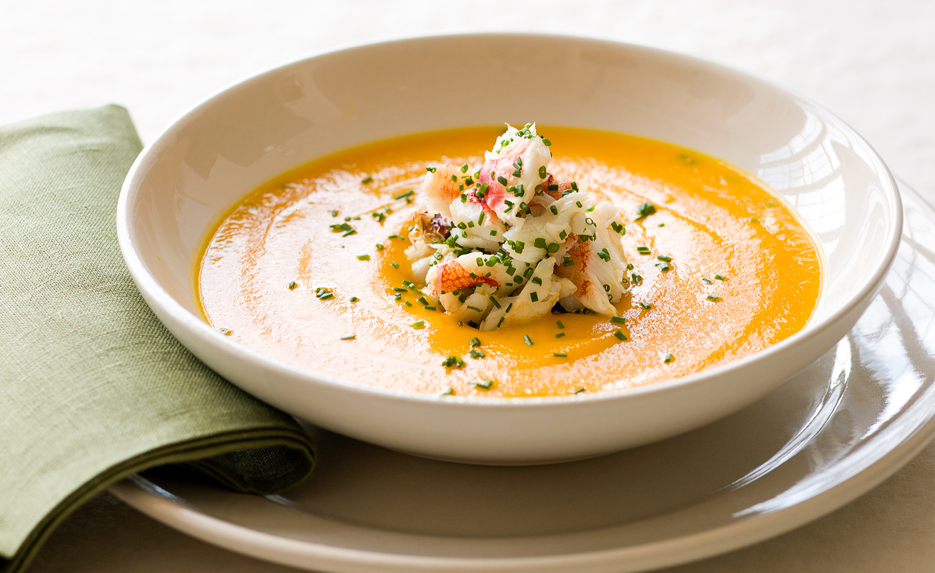Bowl of carrot soup with Dungeness crab
