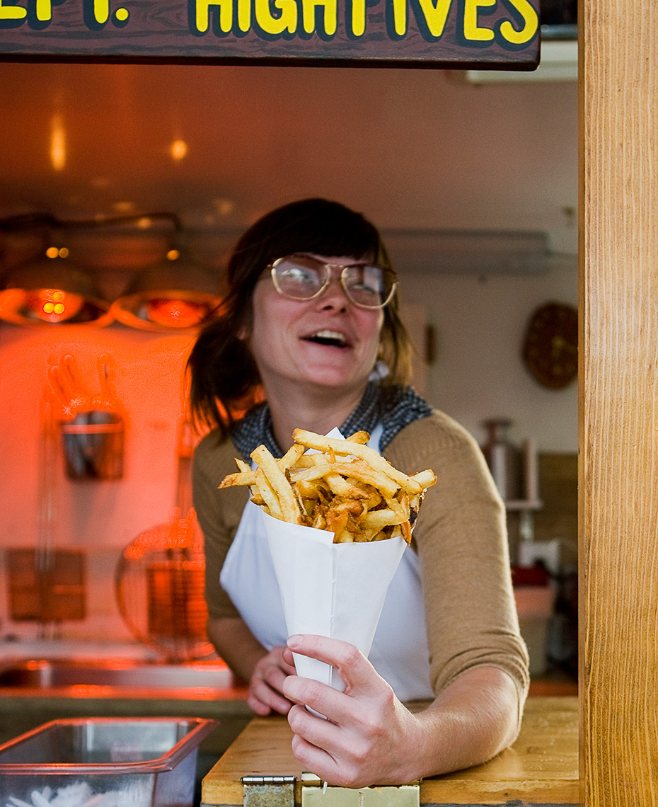 Young woman serving French fries