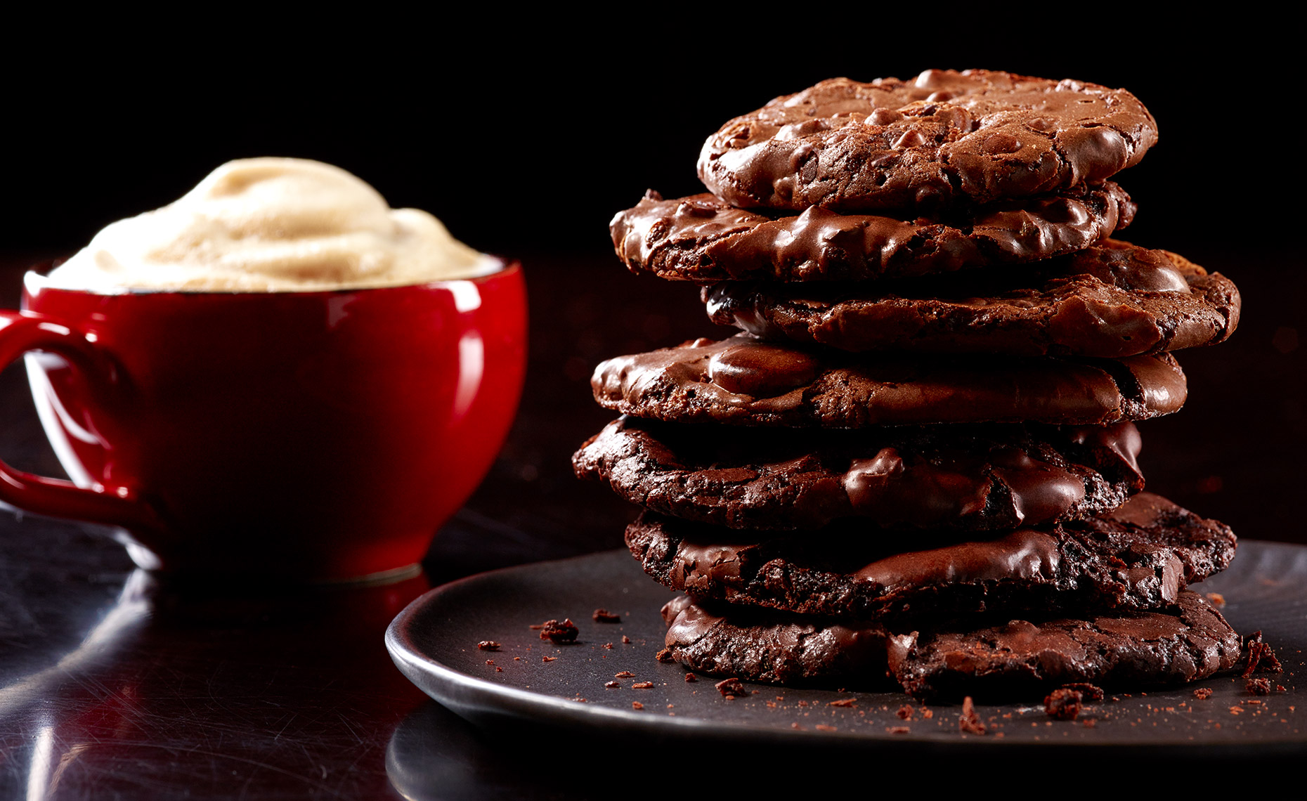 Stack of chocolate chocolate cookies and cup of espresso