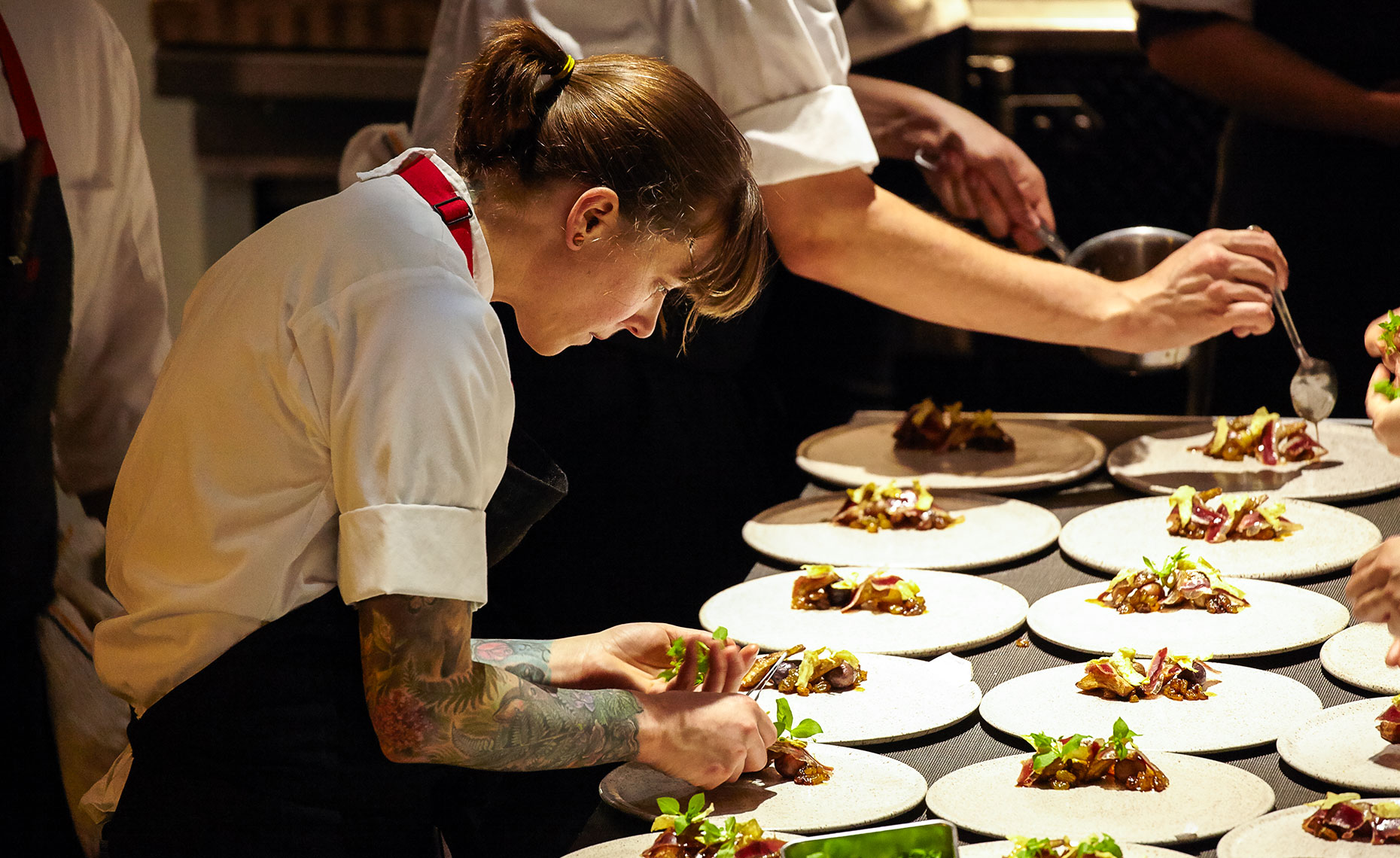 Female chef in restaurant plating entrees 