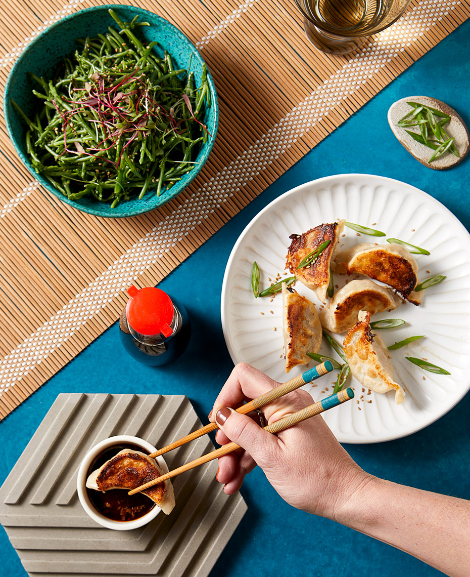 Person enjoying a plate of gyoza