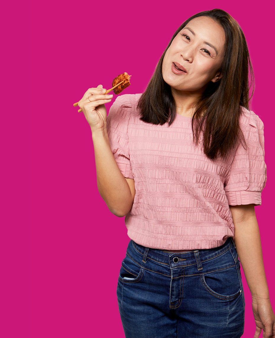Asian woman enjoying food using chopsticks