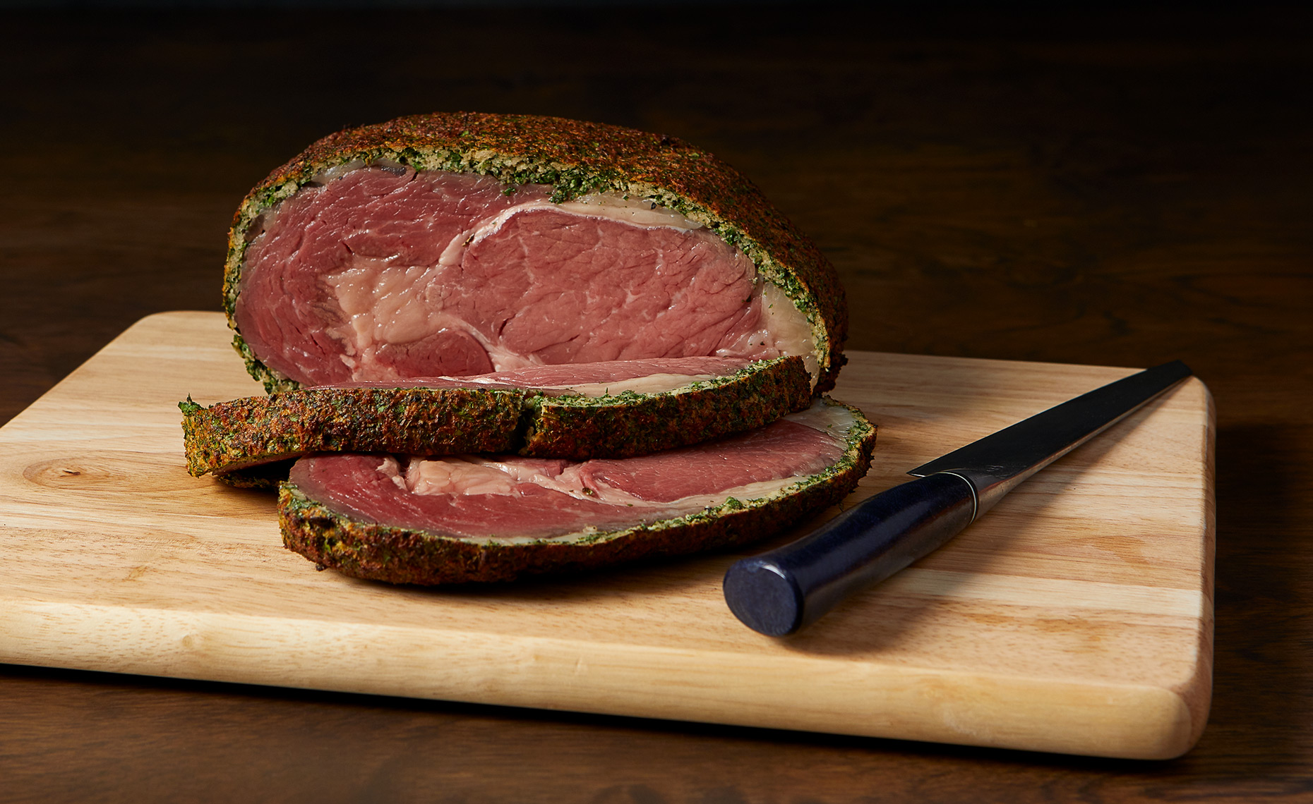 Roasted herb crusted rib eye steak on cutting board